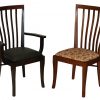 2 wooden kitchen chairs in a dark and light color, respectively, with cushions