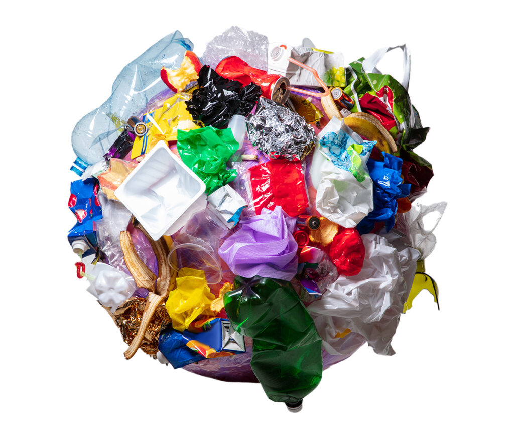 Pile of mixed recyclable plastics, bags, and containers ready for recycling into poly lumber.