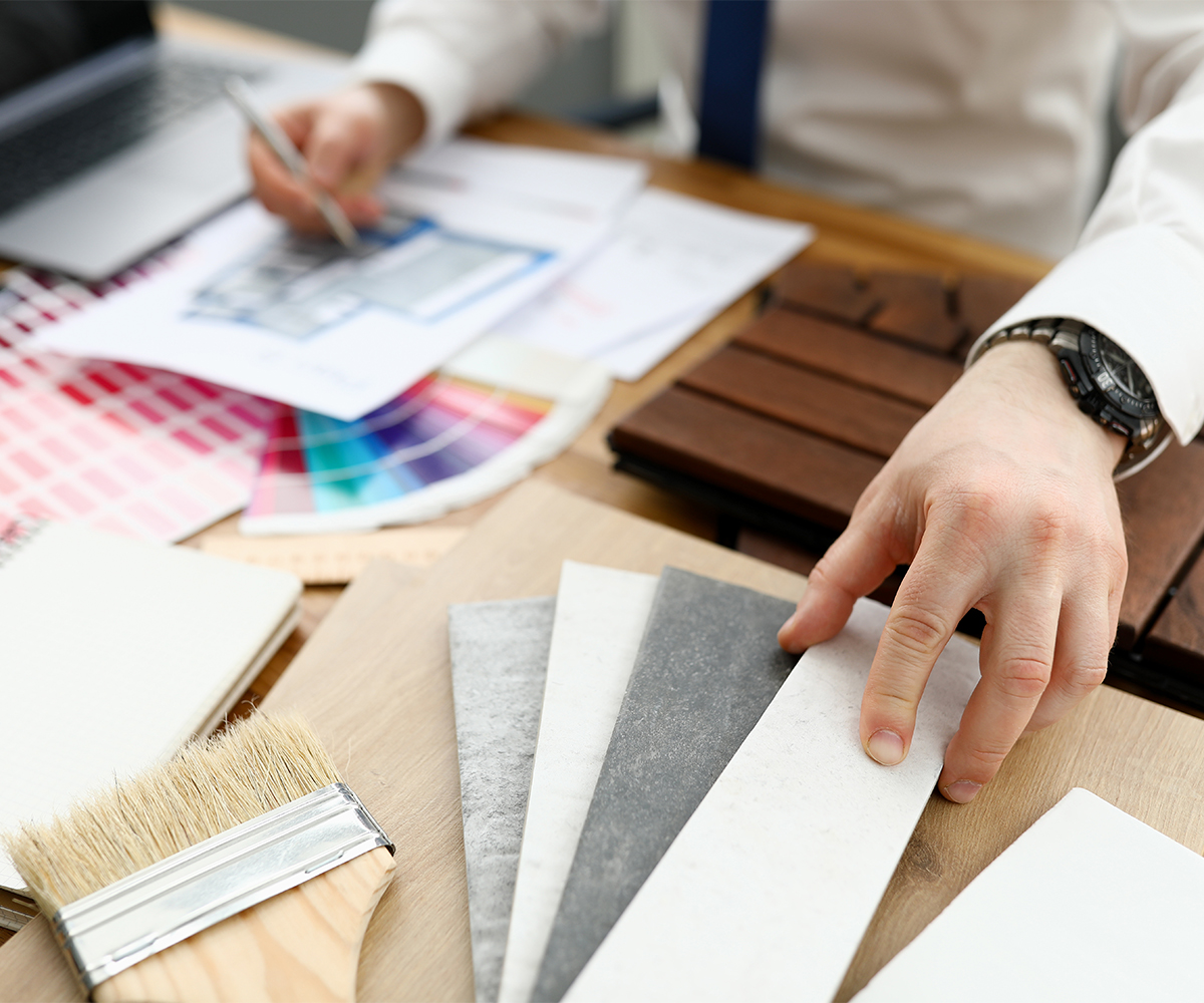 Interior designer reviewing material samples, swatches, and color palettes—collaborating with Amish furniture makers for a custom design.