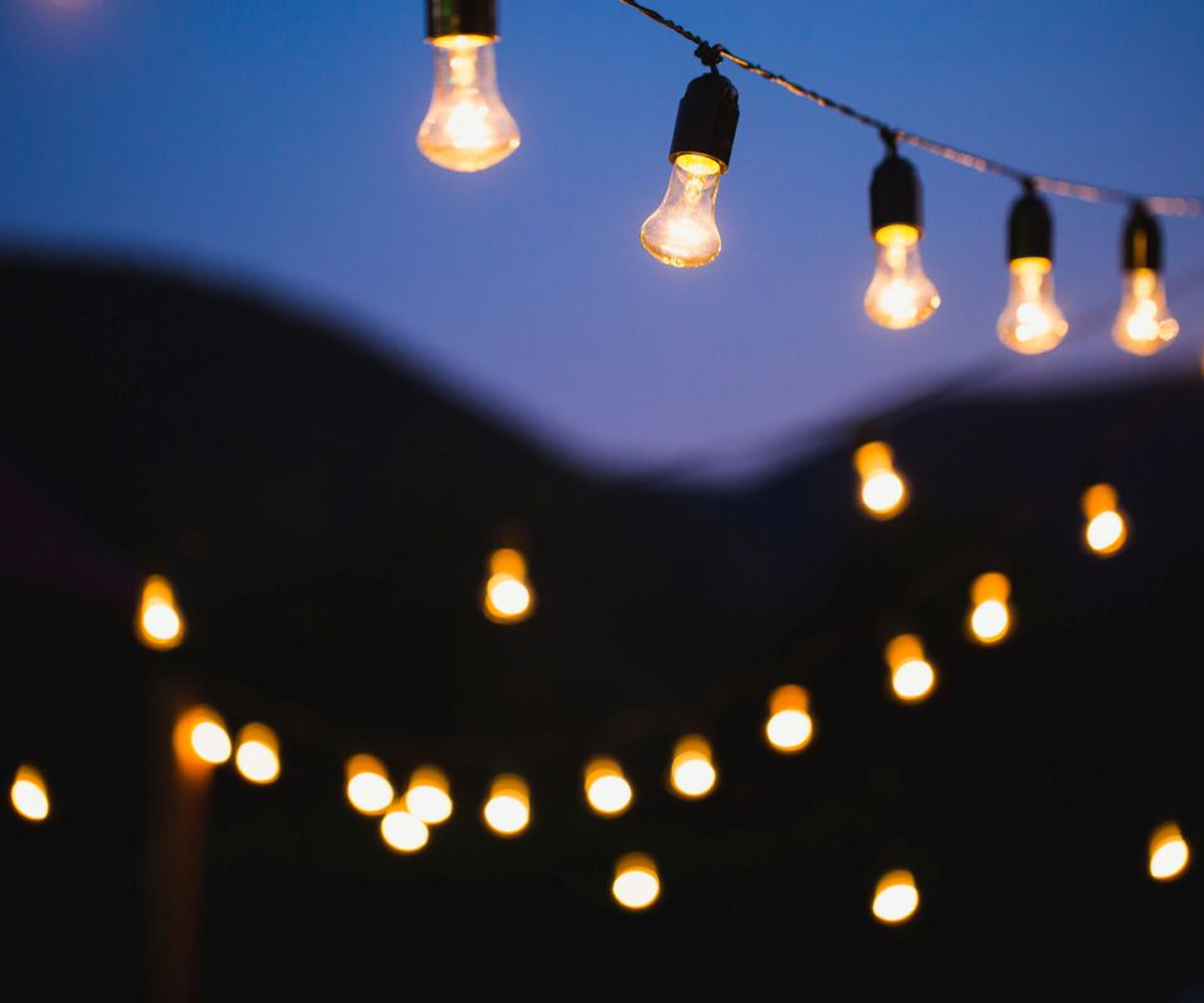 String lights glowing at dusk in an outdoor space.