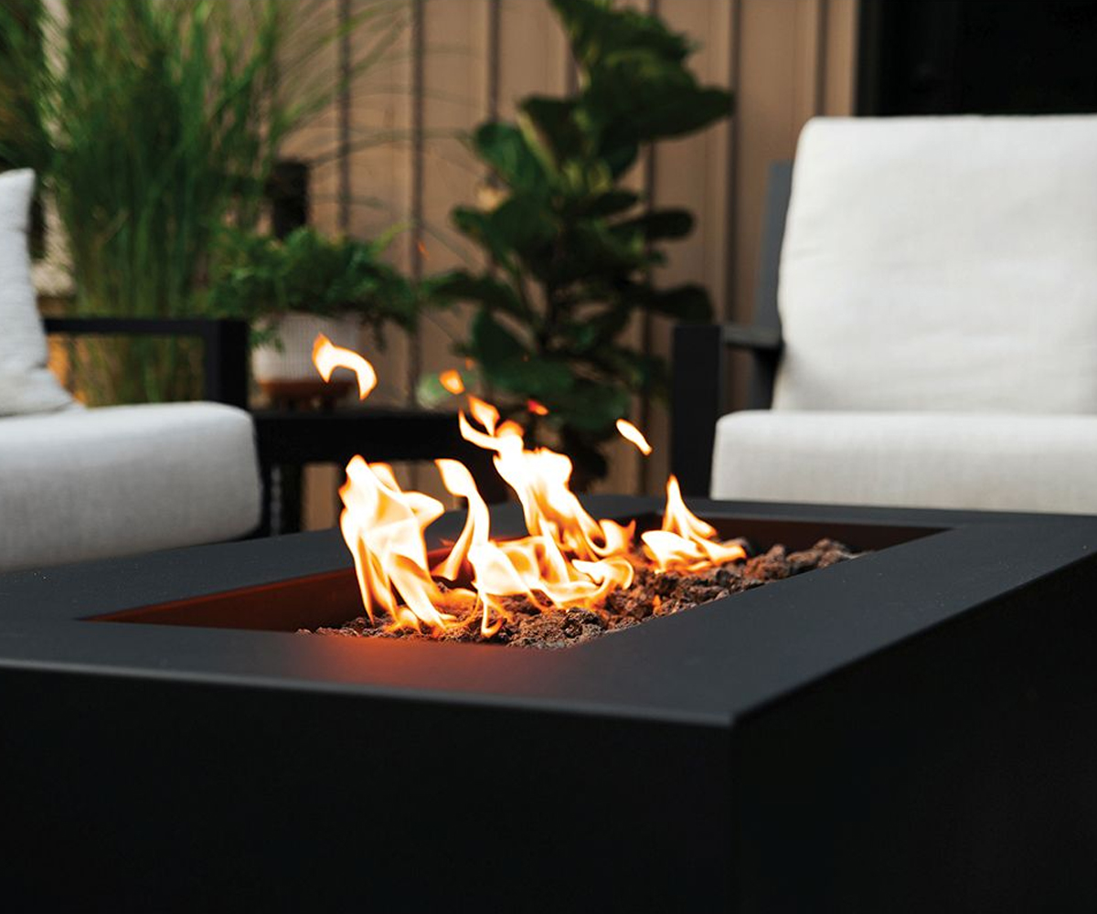 Modern outdoor fire table with flames and seating area.